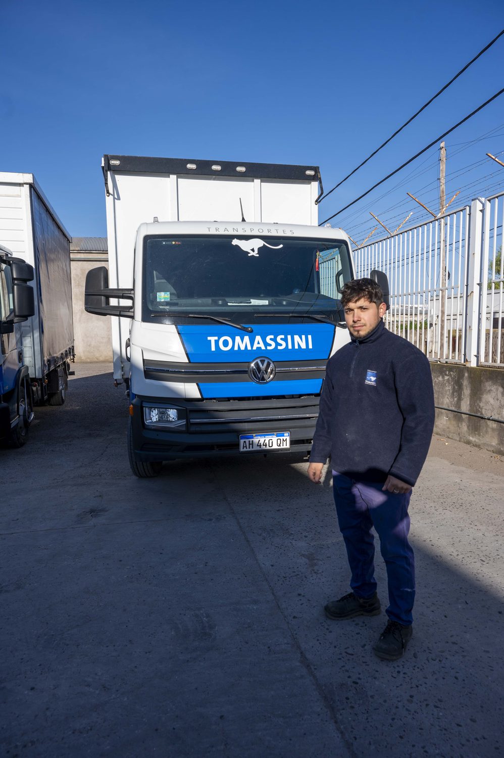 Operario de Transportes Tomassini junto a una unidad en la base.
