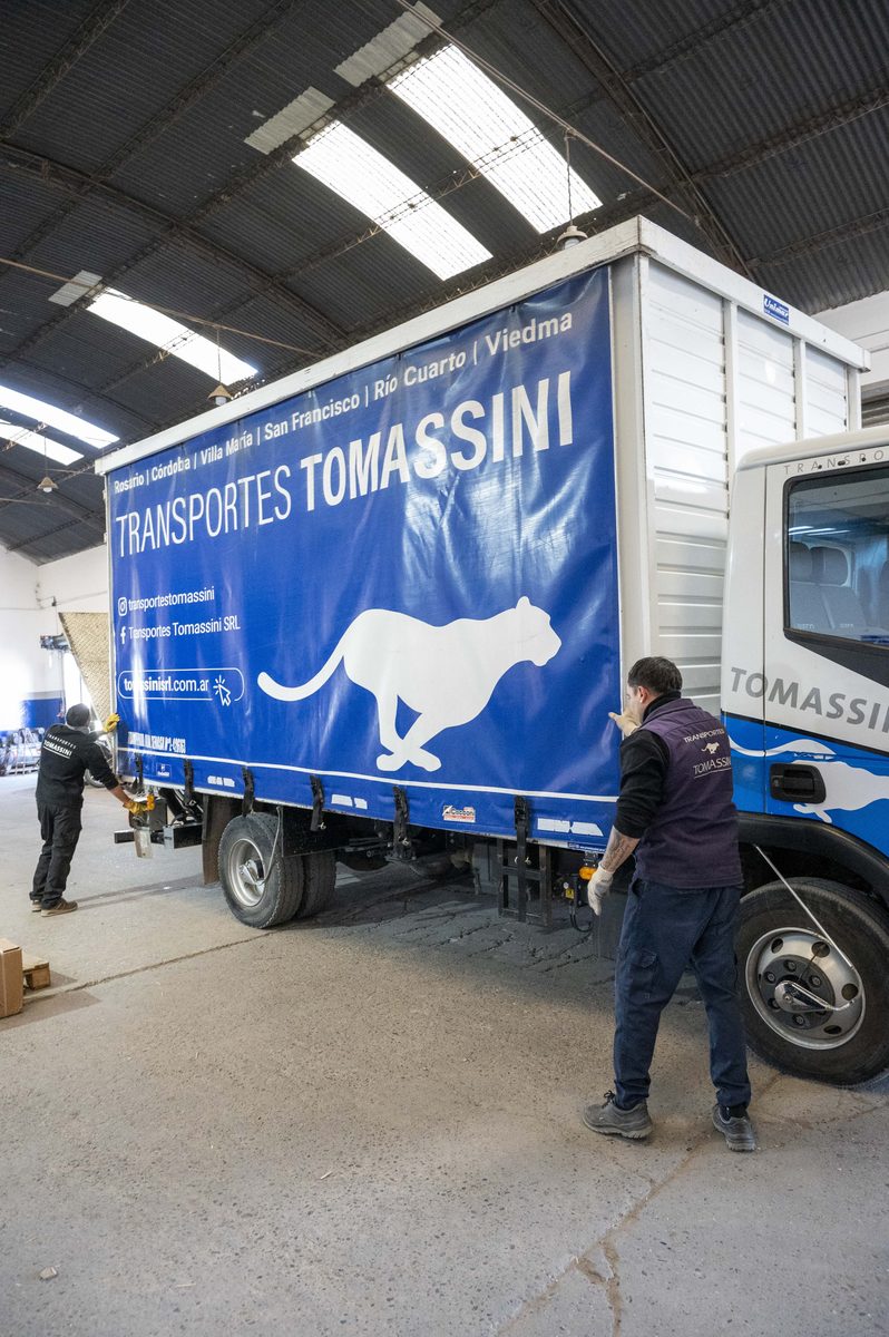 Semirremolque de Transportes Tomassini con la lona de marca, durante la preparación de carga.